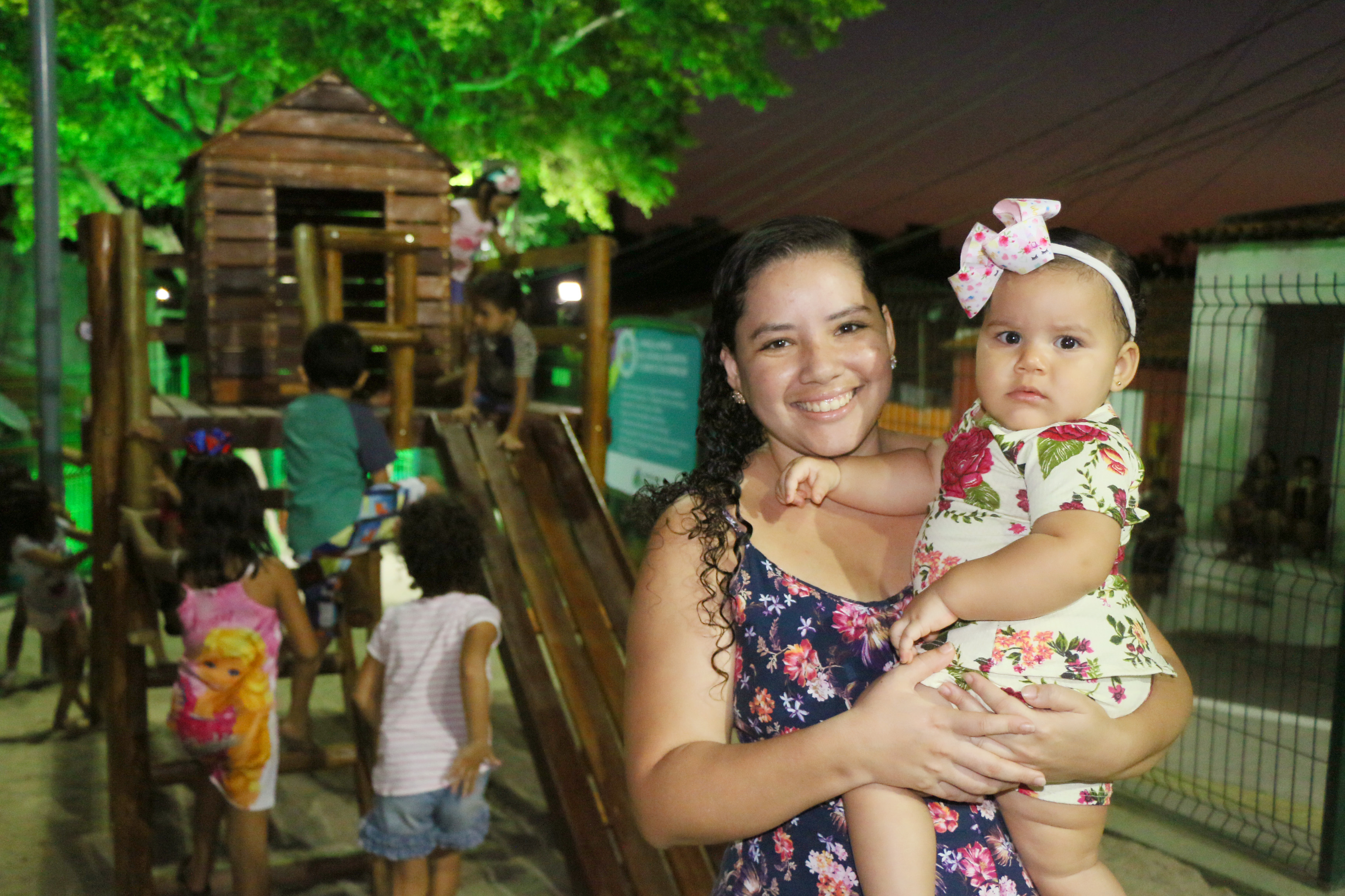 mulher segurando uma menina no braço